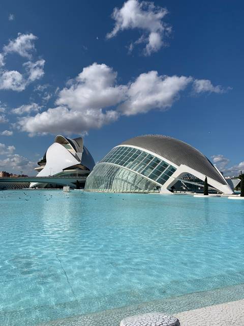 Futuristic architecture with glass and water reflections.
