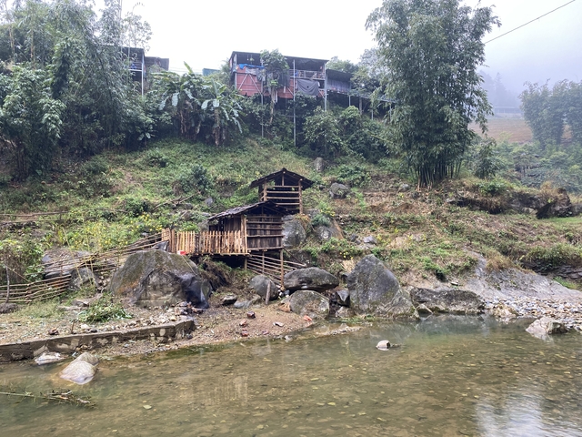       Traditional wooden houses by a small river.
  