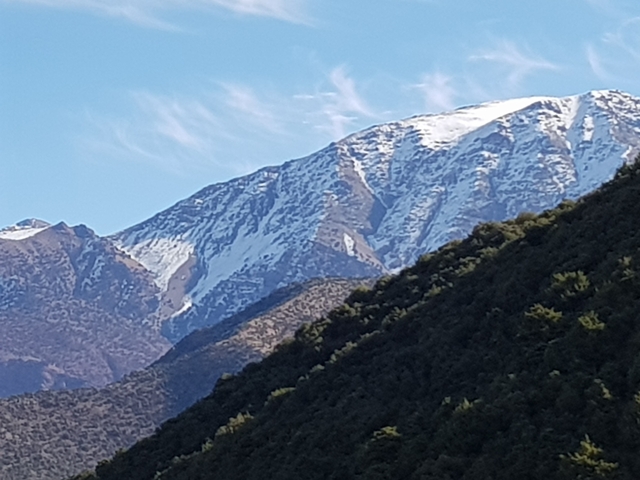 Snow-capped mountain peaks with clear blue sky.