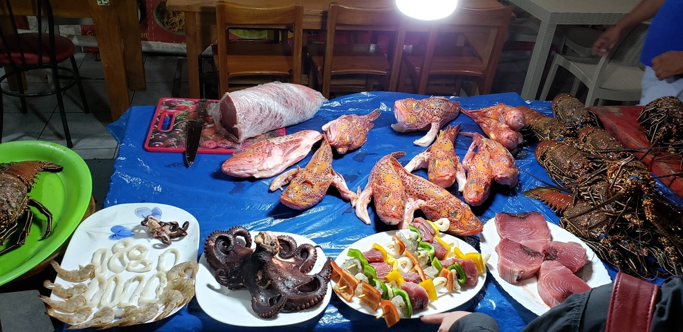       Assortment of seafood on a table for sale.
  