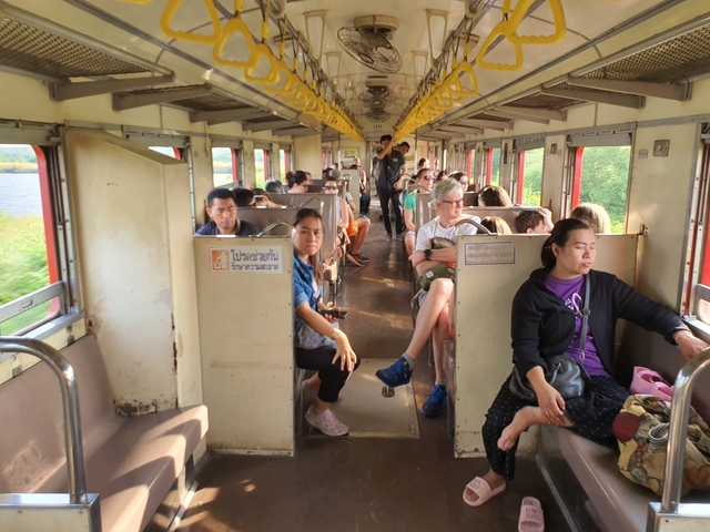 People traveling in a train with open windows showing landscape