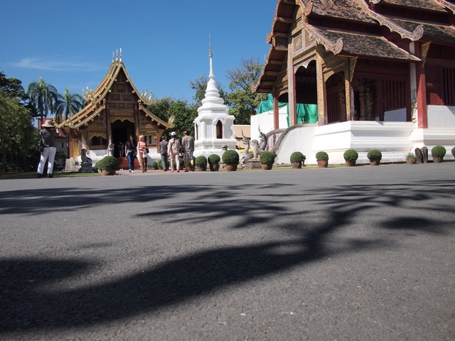 Visitors exploring a temple complex with traditional architecture