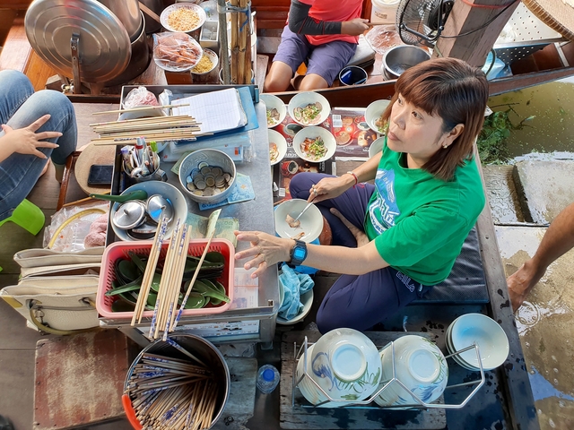 Vendor preparing food at a floating market
