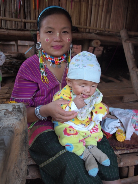 Close-up of a toddler being held by an adult in traditional attire