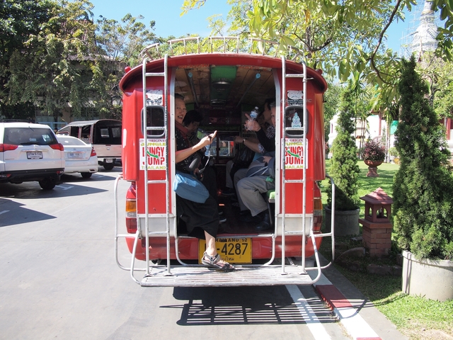 Tourists enjoying a ride in a red tuk-tuk