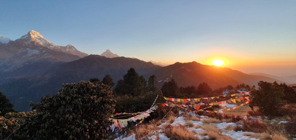       Mountains with prayer flags and sunrise.
  