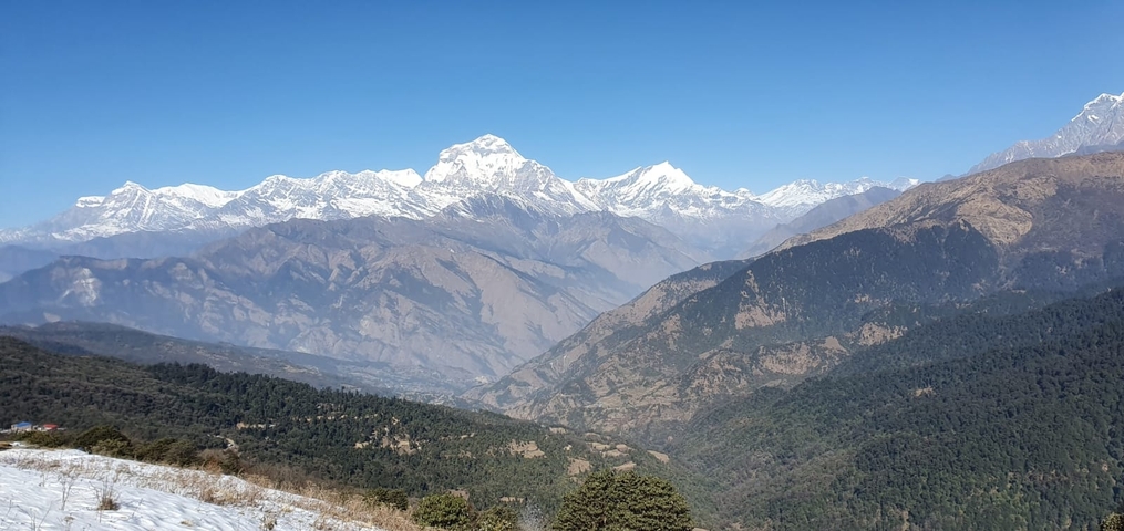       Mountain range with snow under clear blue sky.
  