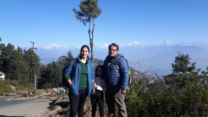 A family posing with mountains in the background.