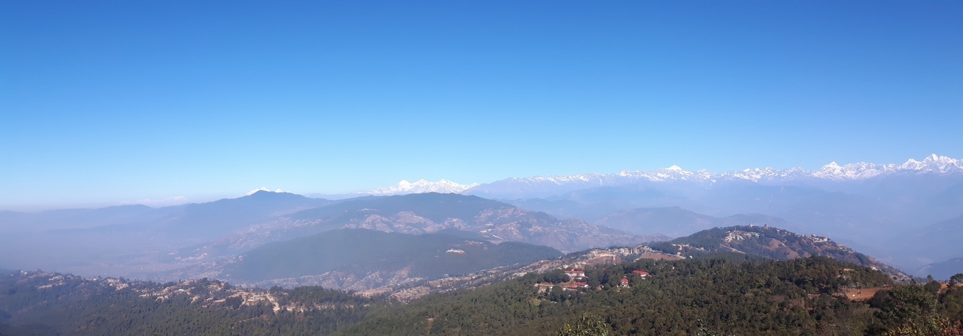 A wide mountain landscape with distant peaks.