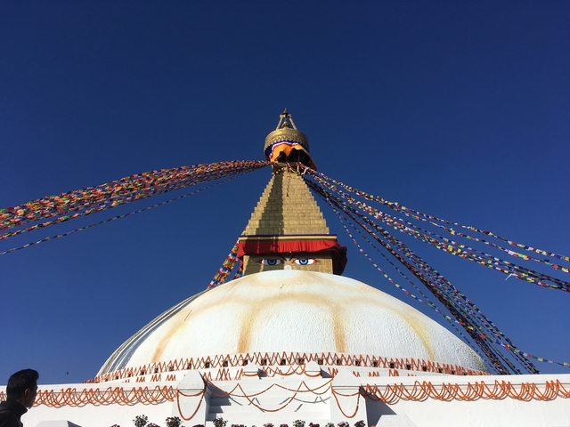 Boudhanath Stupa with colorful flags on a clear day.