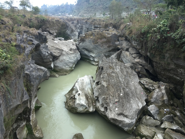A rocky river gorge with still water.
