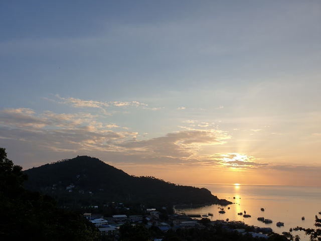 Sunset over the ocean with an island in the distance.