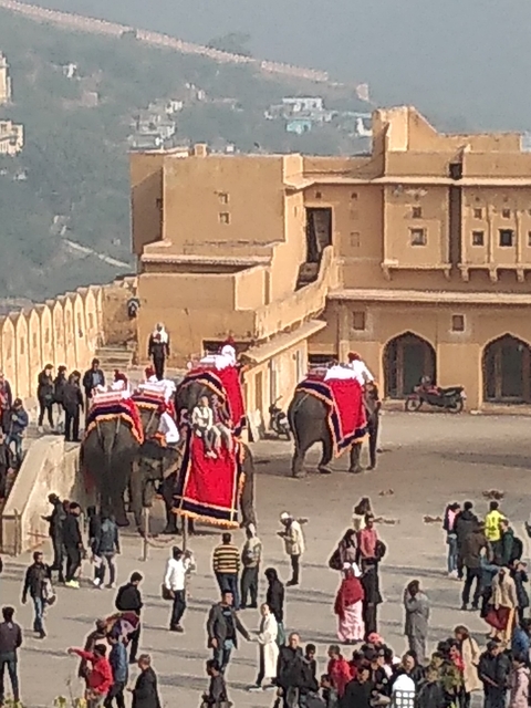 People riding elephants on a palace ramp.