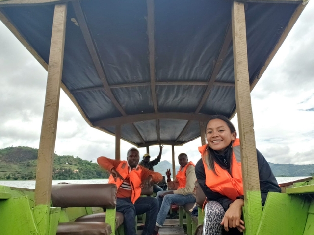       Group of people on a boat on a lake, wearing life jackets.
  