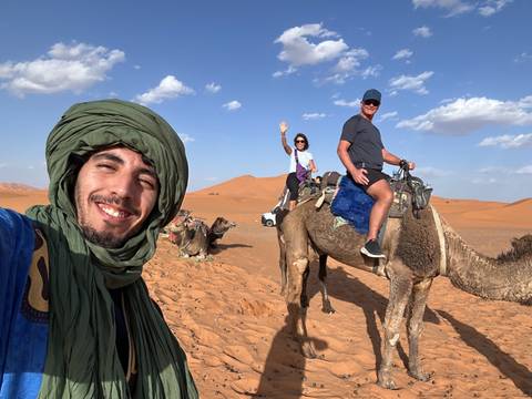Upside-down image of people riding camels in the desert.