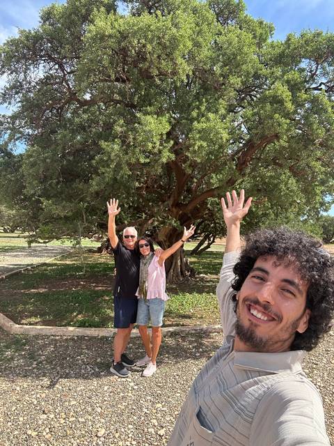 Group selfie in front of a large tree in a park.