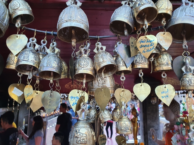Decorative hanging bells with inscriptions at a temple.