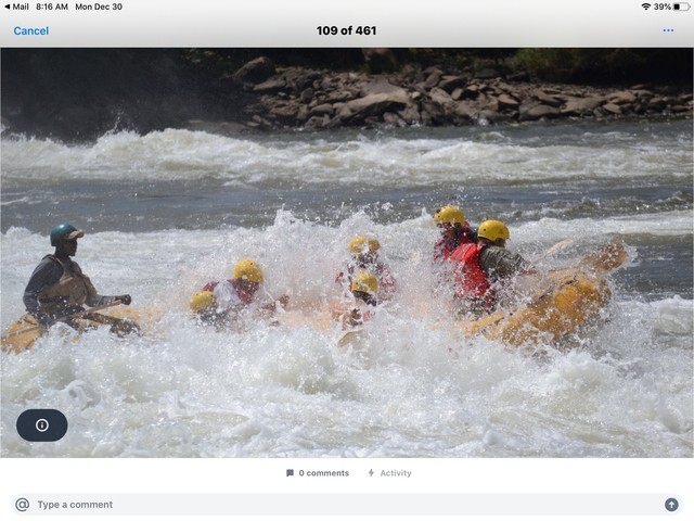 People white-water rafting on a river with rapids.