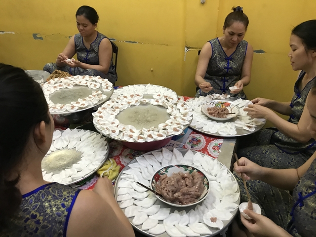       Women preparing traditional meals with dumplings.
  