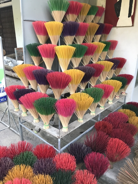       Bundles of colorful incense sticks on display.
  