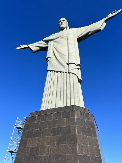       Iconic statue of Christ the Redeemer against a blue sky.
  