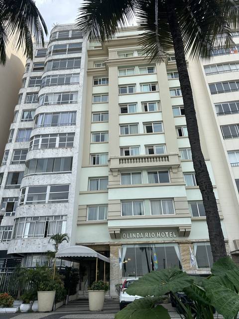 Hotel building with prominent sign and palm tree in view.