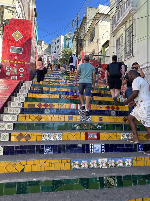       Colorful tiled stairs with people ascending them.
  