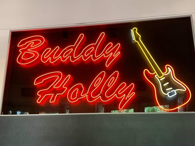 Neon sign with text 'Buddy Holly' and a guitar.