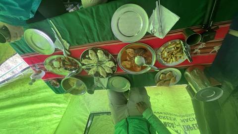 Plates of food on a table with a person standing nearby.