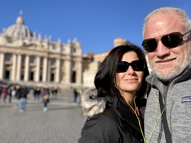 Couple posing in front of a grand European cathedral.
