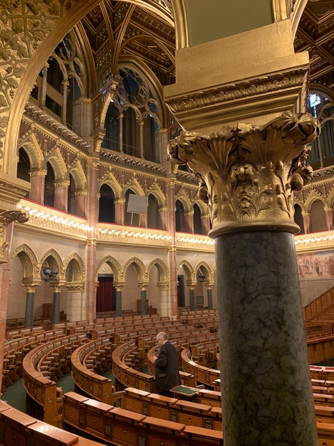 Luxurious interior of a grand hall with ornate columns and arches.