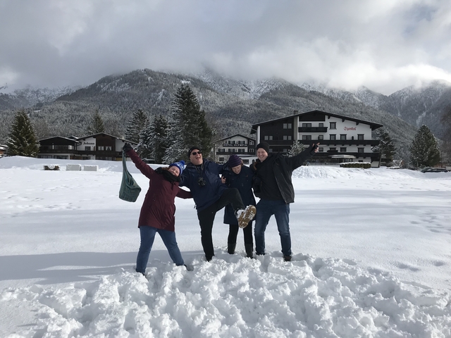 Group of people playfully posing in snowy mountains.
