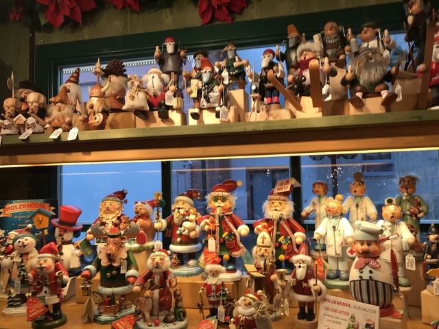 Wooden display of traditional toys and figurines in a shop.