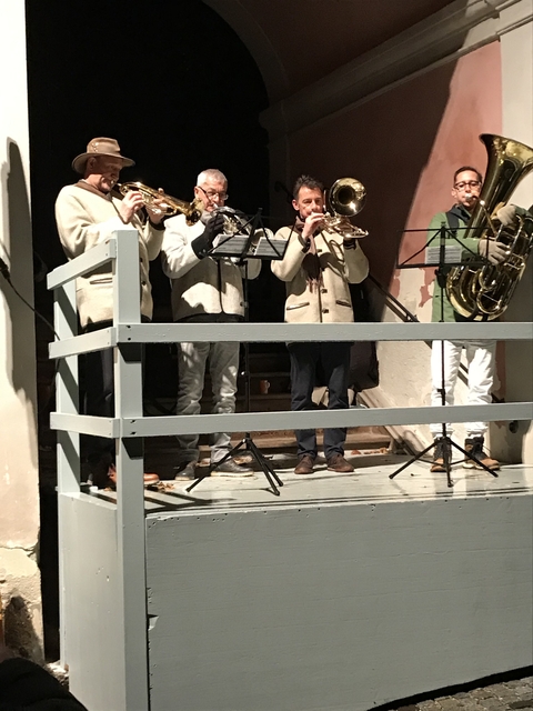 Musicians playing instruments on a small stage.
