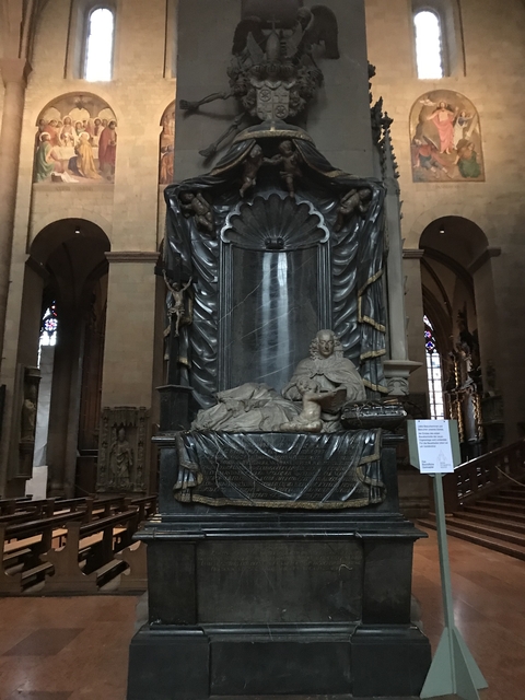 Intricate sculpture inside a cathedral with a marble statue and religious motifs.