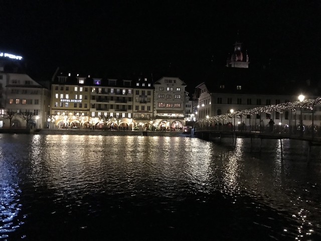 Night view of a city with reflections on water.