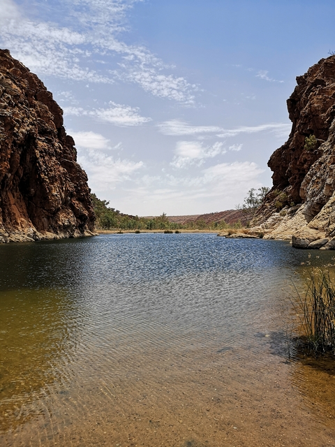 Lake surrounded by rocky cliffs and clear sky.