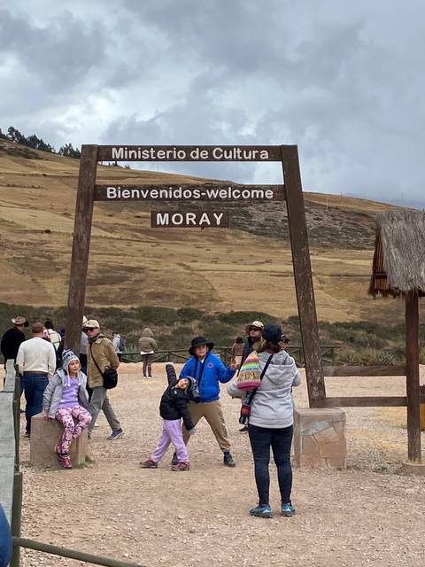      Tourists posing near the Moray sign in Peru
  
