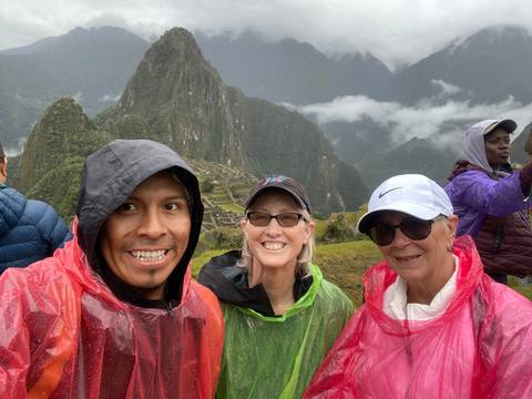       Group of people in colorful ponchos with mountain scenery in the background.
  
