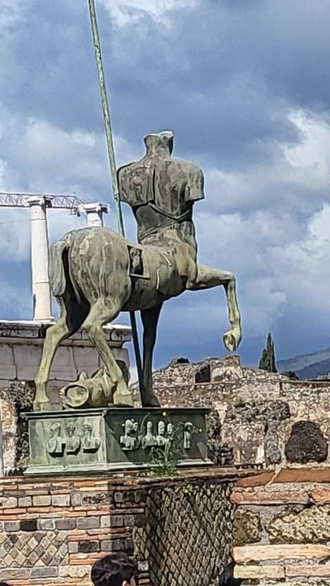       Statue of a rider on a horse amid ancient ruins.
  
