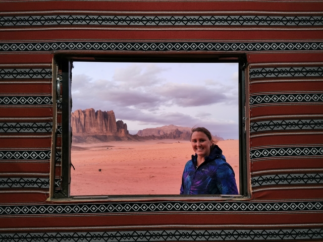 Person posing with a view of Wadi Rum in the background.