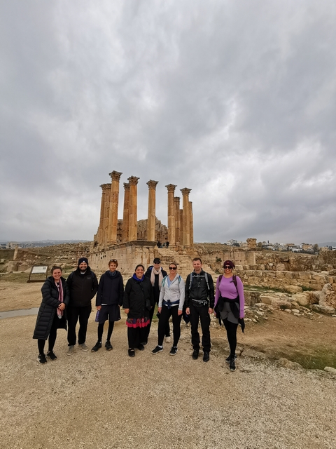 Group in front of ancient Roman ruins.