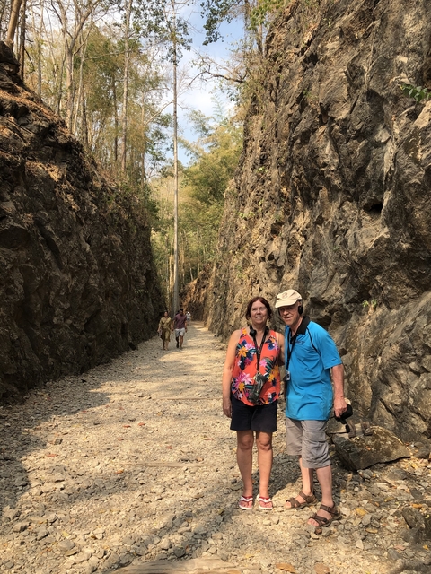 Tourists walking through a narrow rocky path.