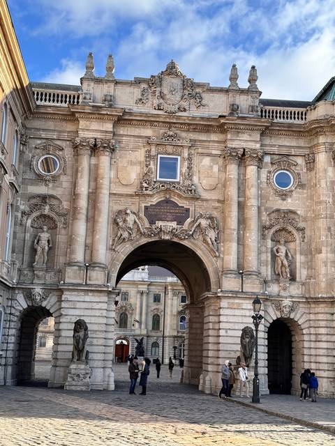 Archway entrance with sculptures and visitors.
