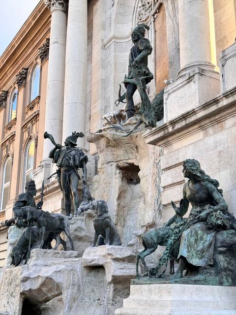 Sculptures near an ornate building facade.