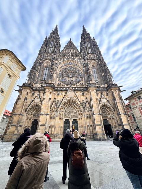Large cathedral facade with tourists taking photos.