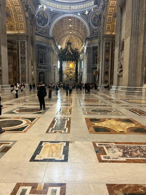 An interior view of a grand hall with intricate mosaic flooring.