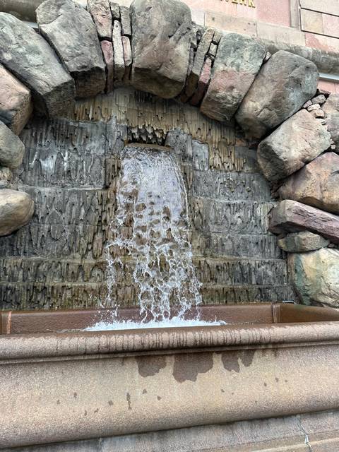 Water flowing over textured rocks in a small fountain.