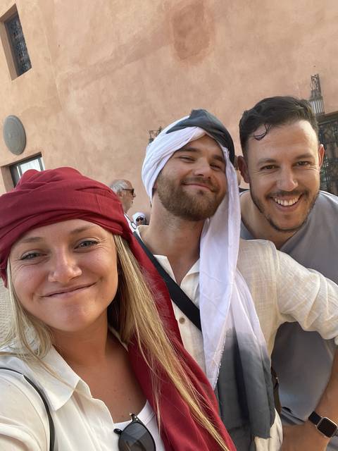 Group of people wearing traditional clothing posing together.