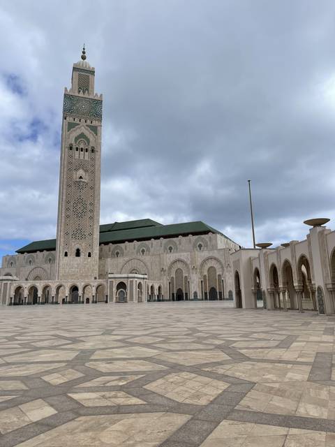Grand mosque with intricate architecture and patterned floors.